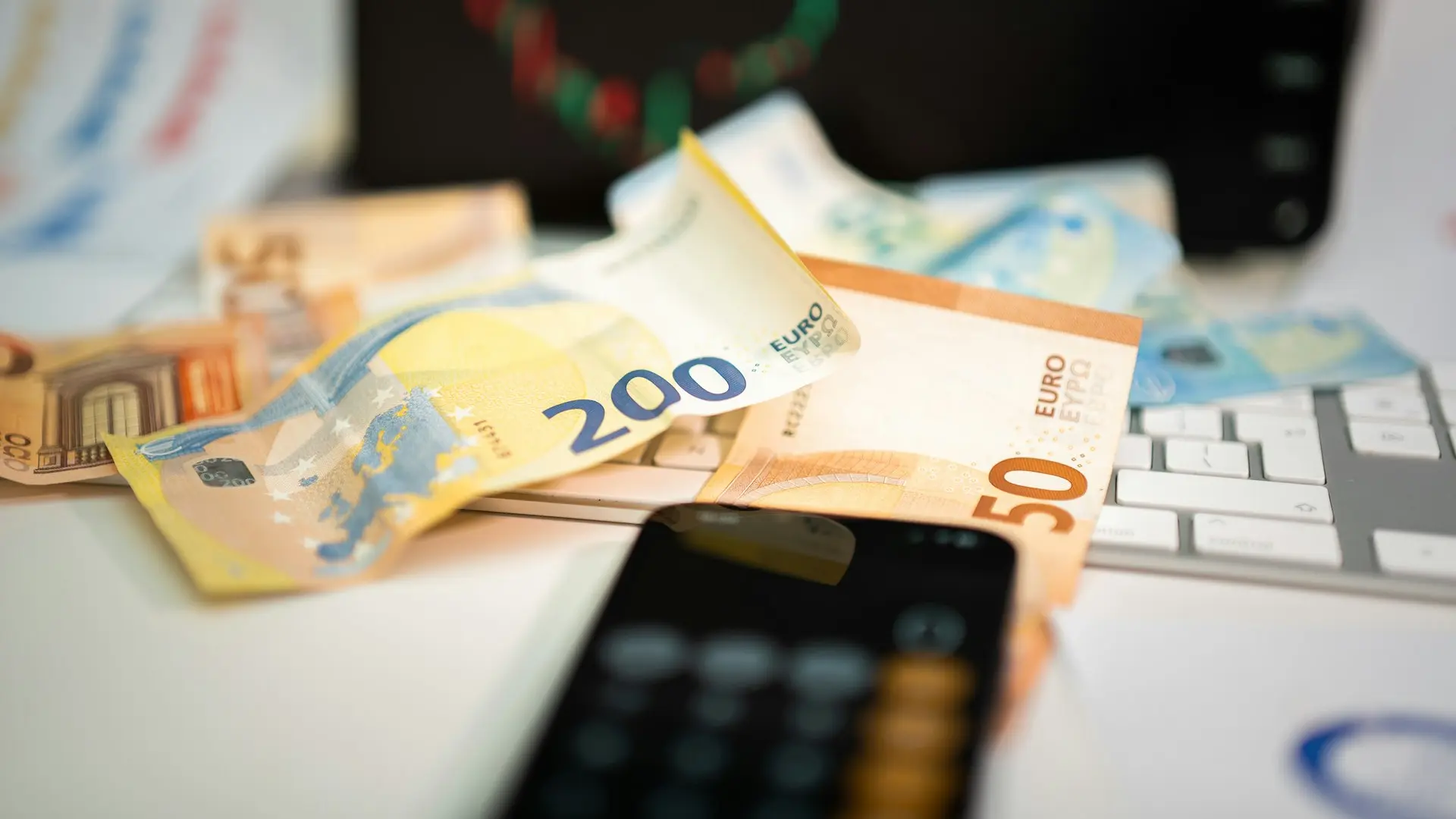 A cell phone sitting on top of a pile of money