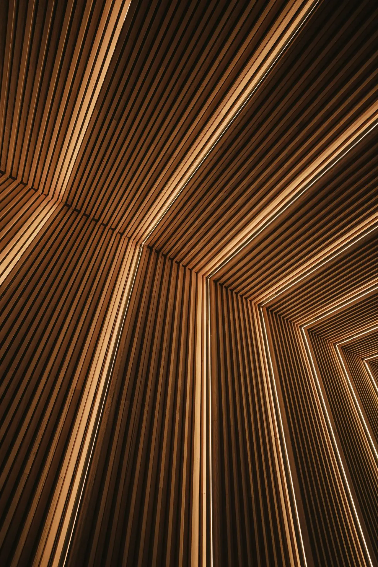 Éclairage architectural à rubans LED intégré dans des panneaux modernes en lattes de bois