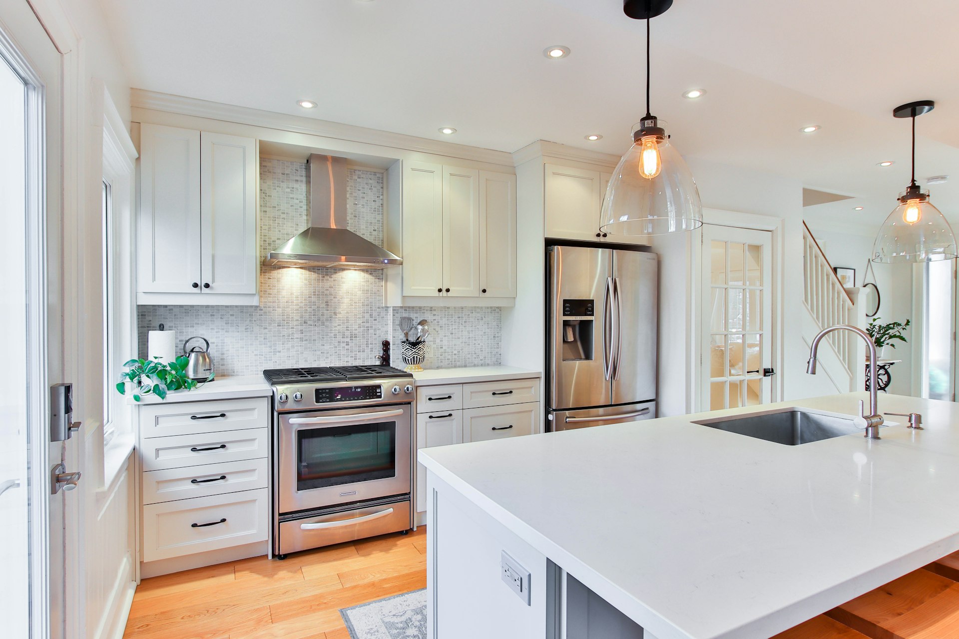 A kitchen with white cabinets featuring intricate millwork white wooden kitchen cabinet and white kitchen counter