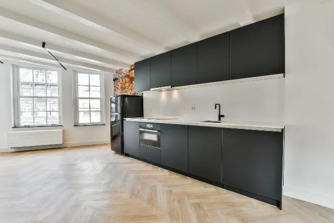 A kitchen showcasing black cabinetry with detailed millwork A modern kitchen featuring sleek black cabinets
