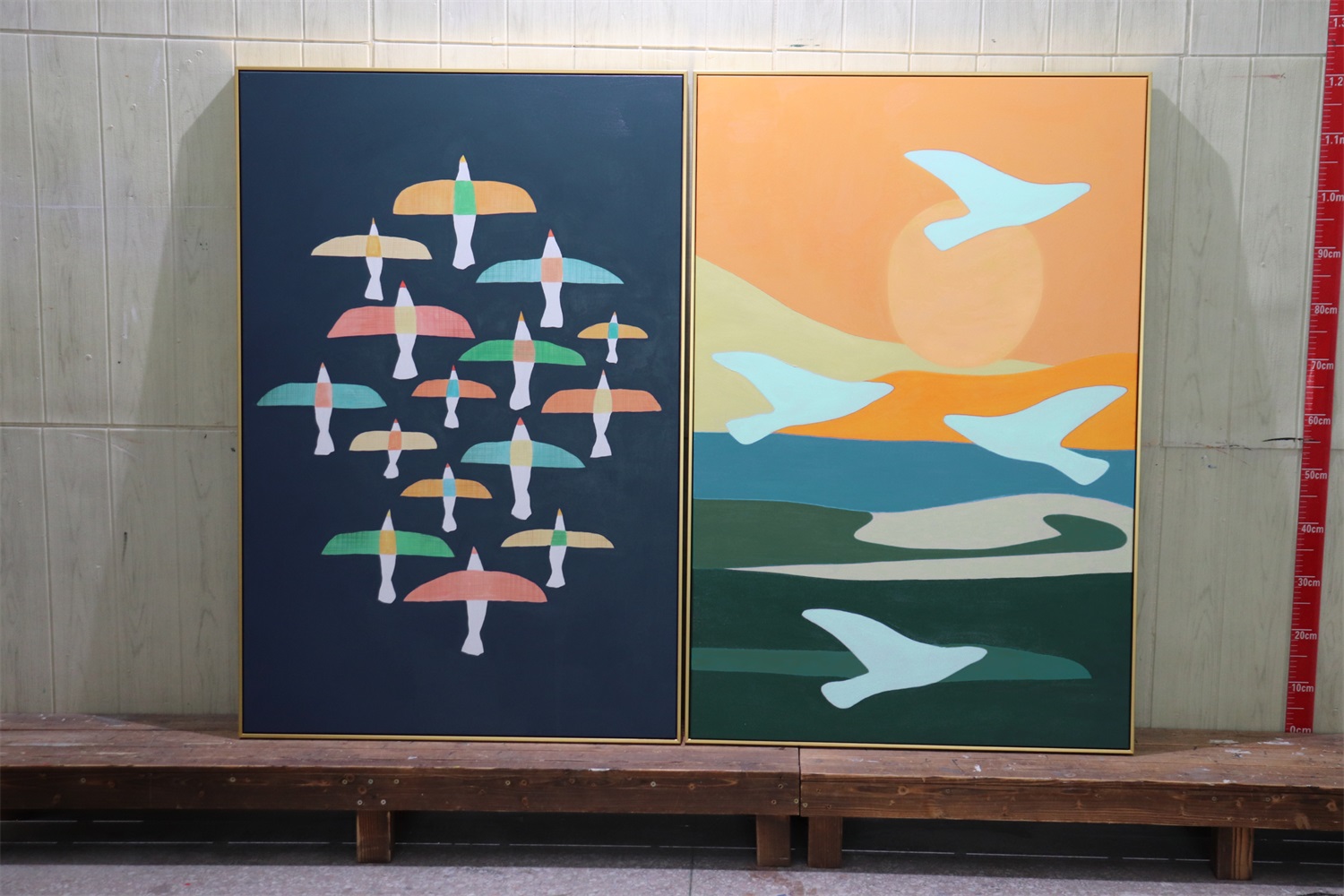 Two abstract paintings featuring colorful birds and a sunset scene.