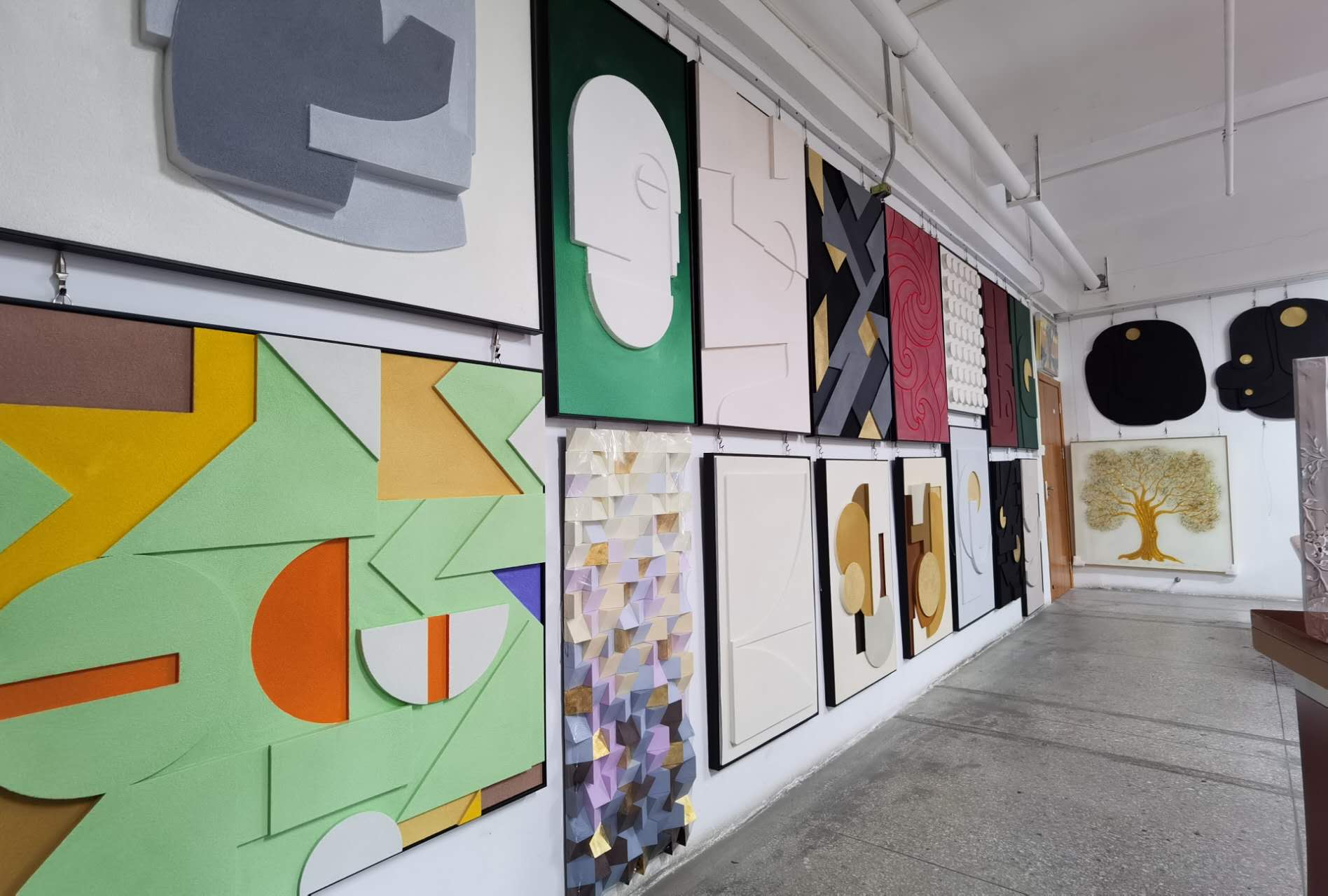 Gallery wall featuring a diverse collection of abstract artworks in various colors and textures.