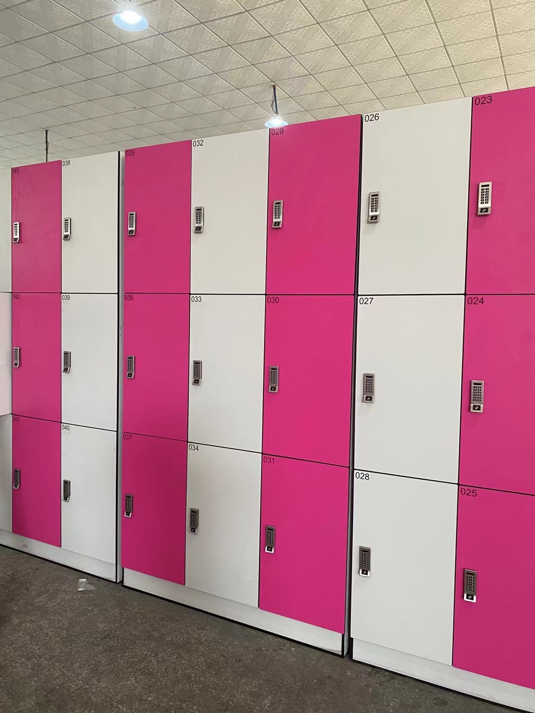  lockers in pink and white arranged neatly in a hallway.