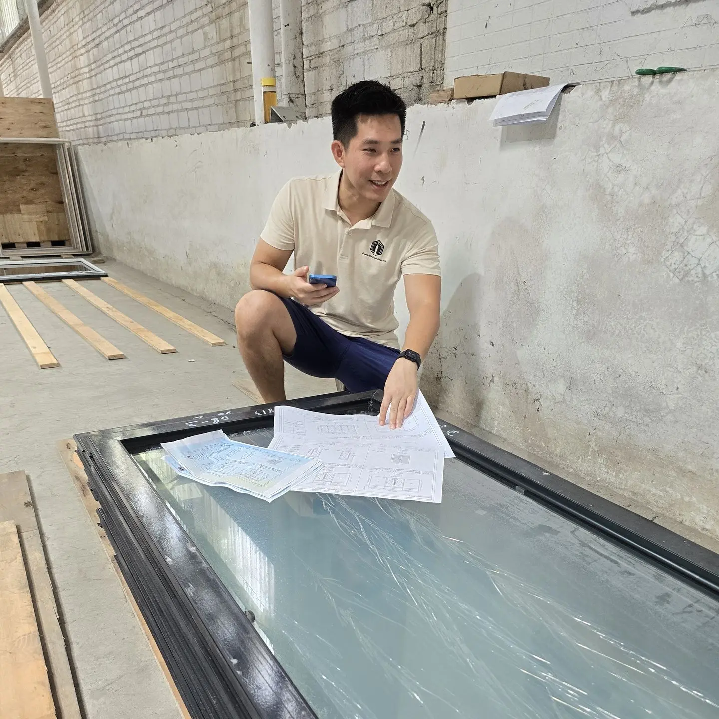 Guangzhou Sourcing Quality Control - Ensuring Accurate Measurements and Specifications Our team carefully examining blueprints on a tabletop in a warehouse setting