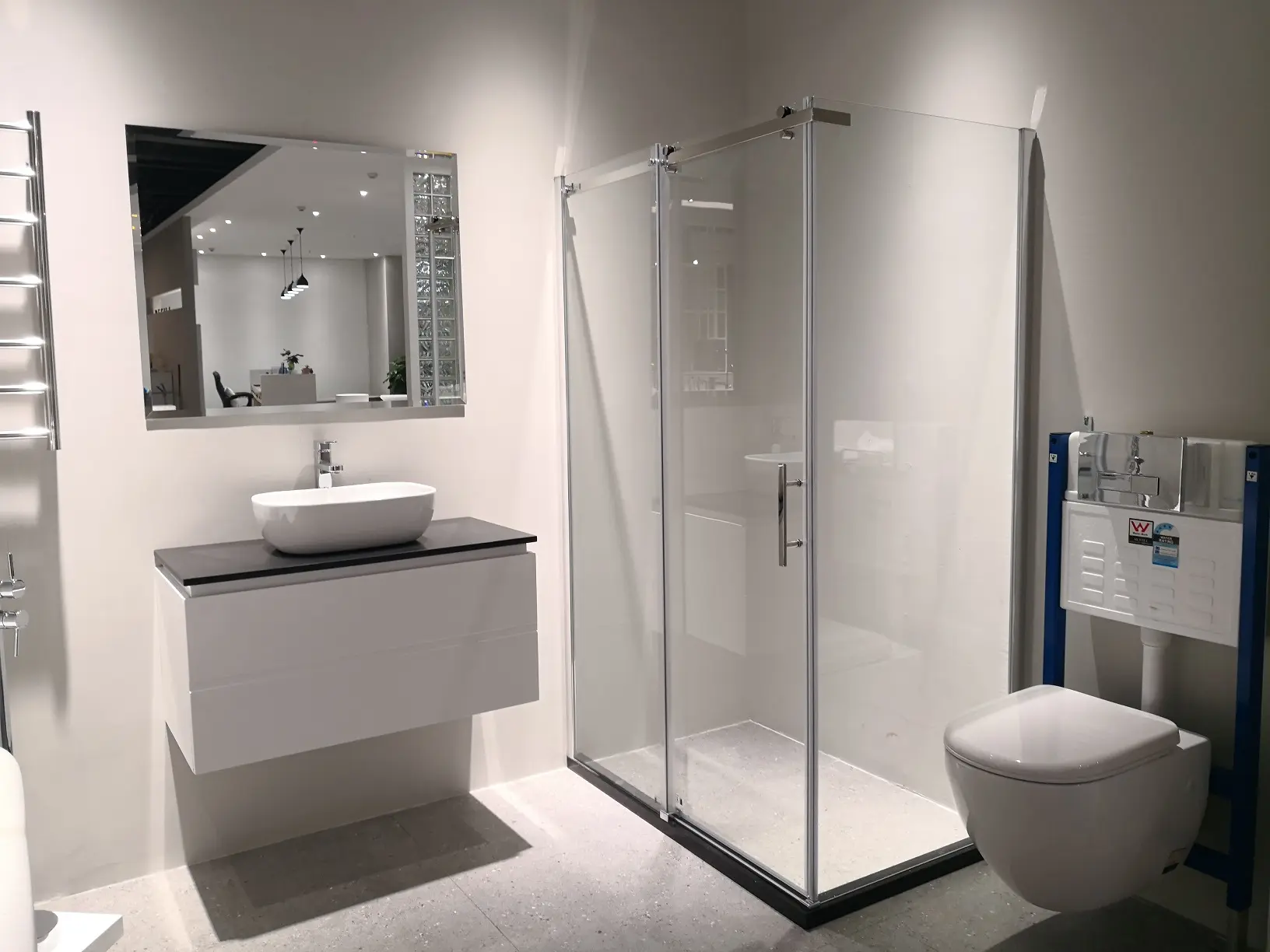 Sleek modern bathroom featuring a glass shower enclosure, wall-mounted sink, and contemporary toilet.