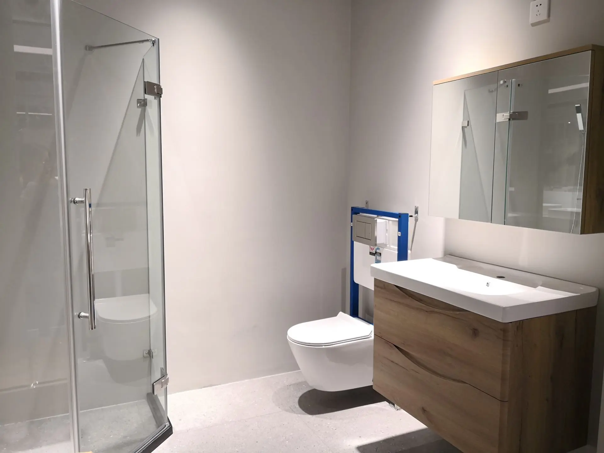 Contemporary bathroom design featuring a glass shower enclosure, wooden vanity with sink, and modern toilet.