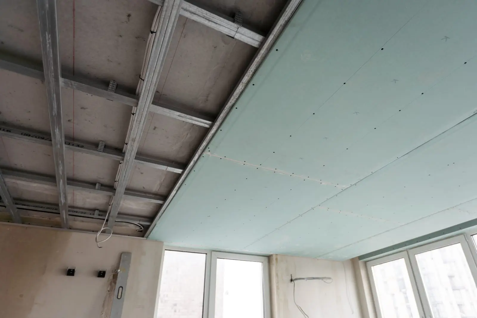 Installation of acoustic ceiling systems with support framework and green panels, designed to reduce noise.