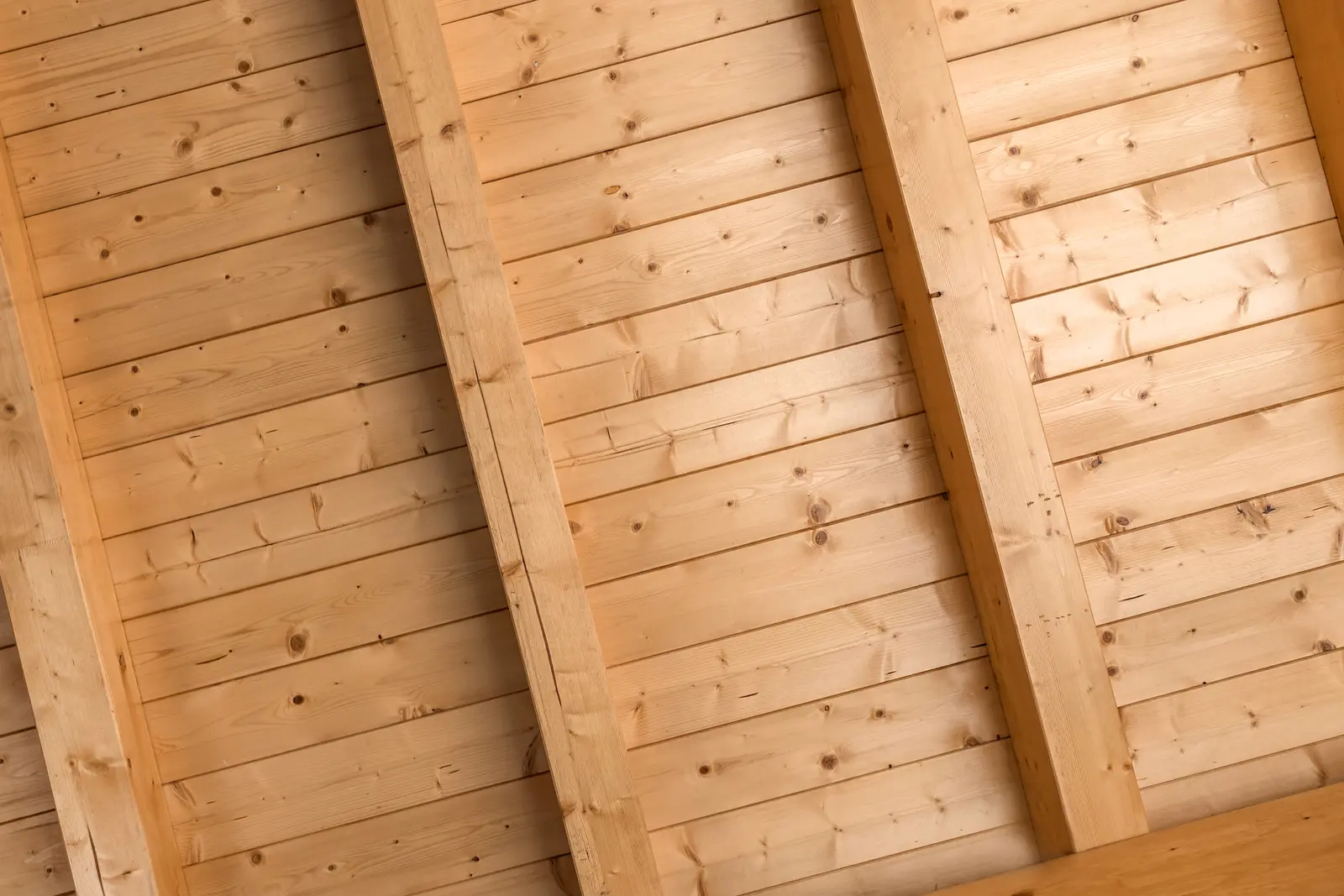 Natural timber ceiling with wooden beams and planks, showcasing craftsmanship and warmth.