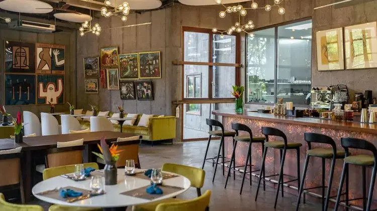  Modern dining area of a restaurant featuring artistic decor, comfortable seating, and a stylish bar.