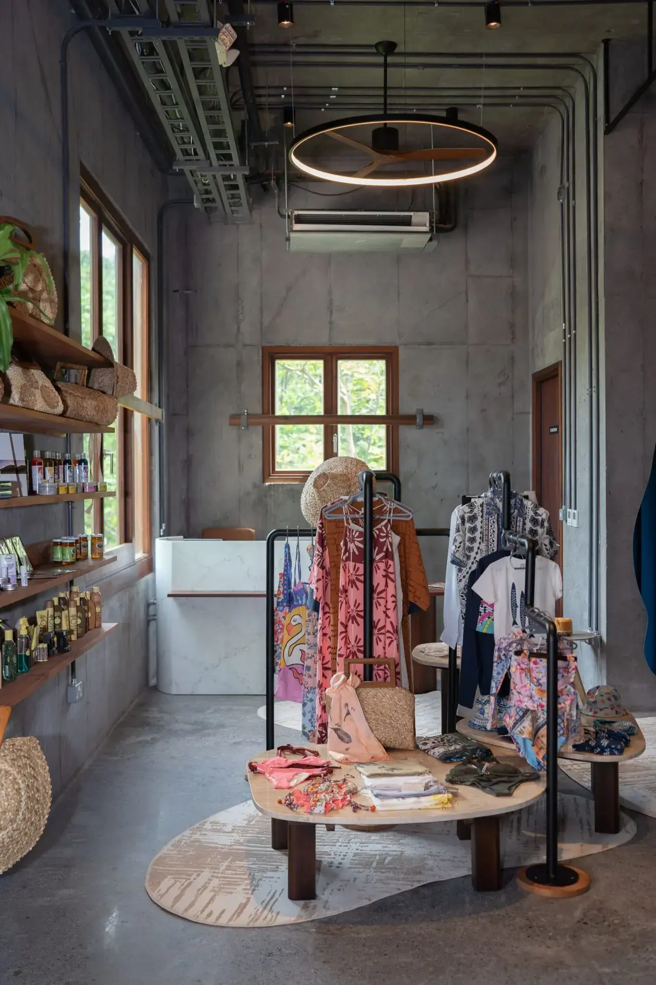 Interior view of a boutique featuring clothing racks and shelves, with a modern industrial design and natural light.