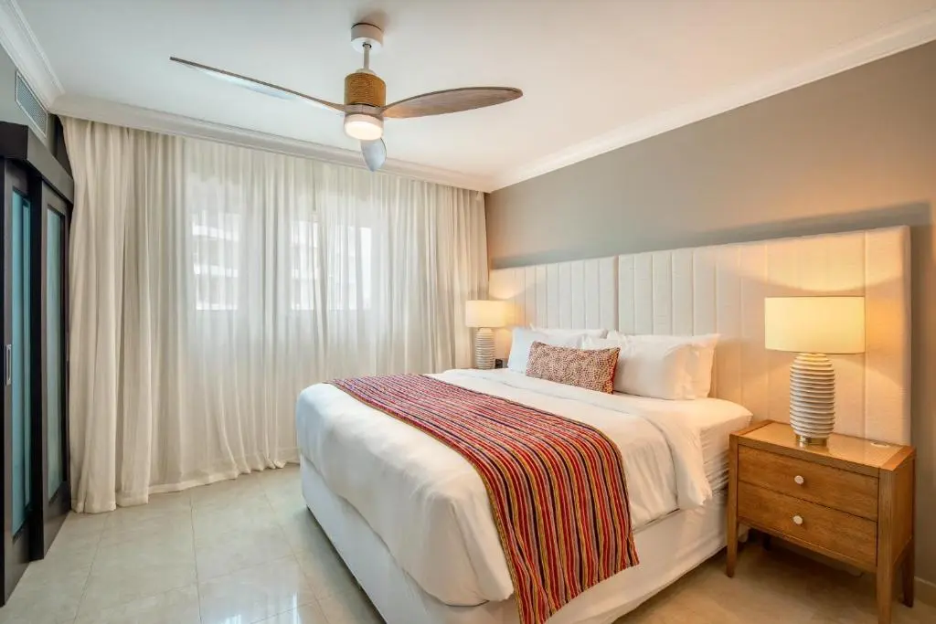 Cozy bedroom featuring a modern design with a stylish headboard, decorative bedding, and warm lighting.