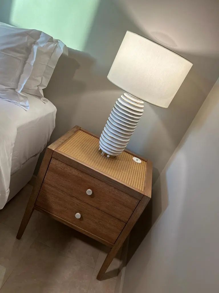 Elegant bedside table with a stylish lamp, showcasing a modern design in a cozy bedroom setting.