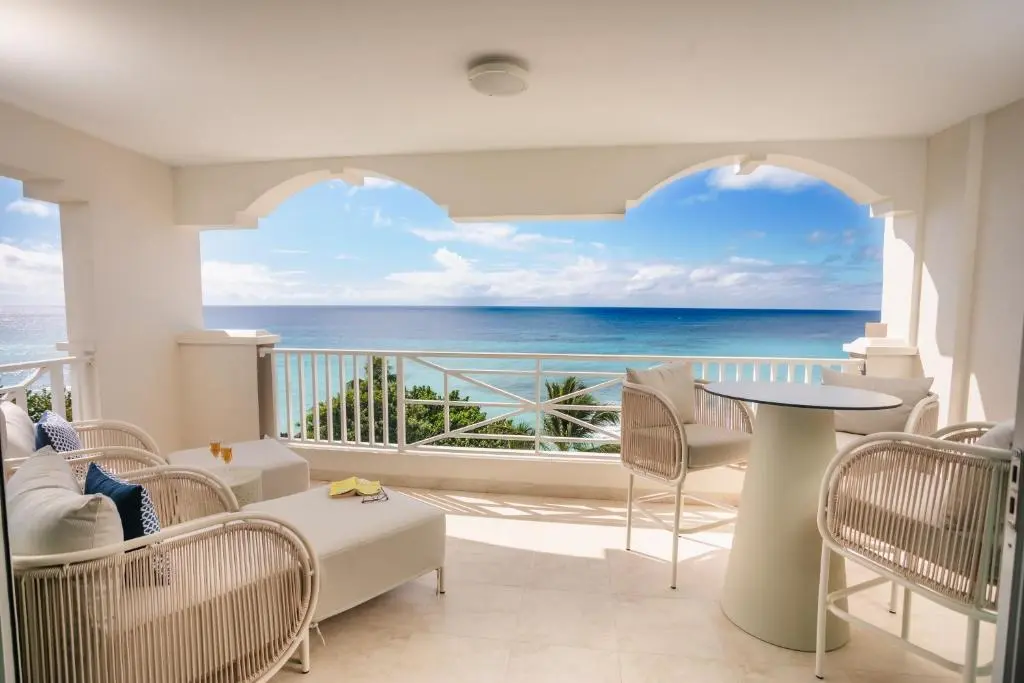 Beautiful balcony with ocean views, featuring comfortable seating and a modern table, perfect for relaxation.
