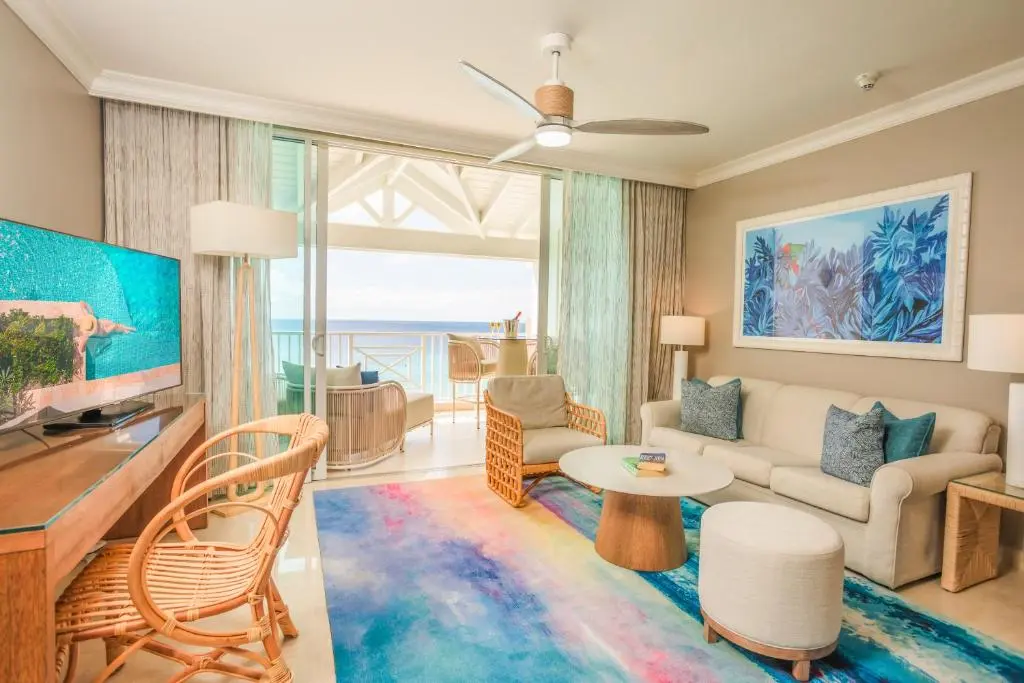 Bright and airy living area with ocean views, featuring modern furniture, vibrant decor, and large windows.