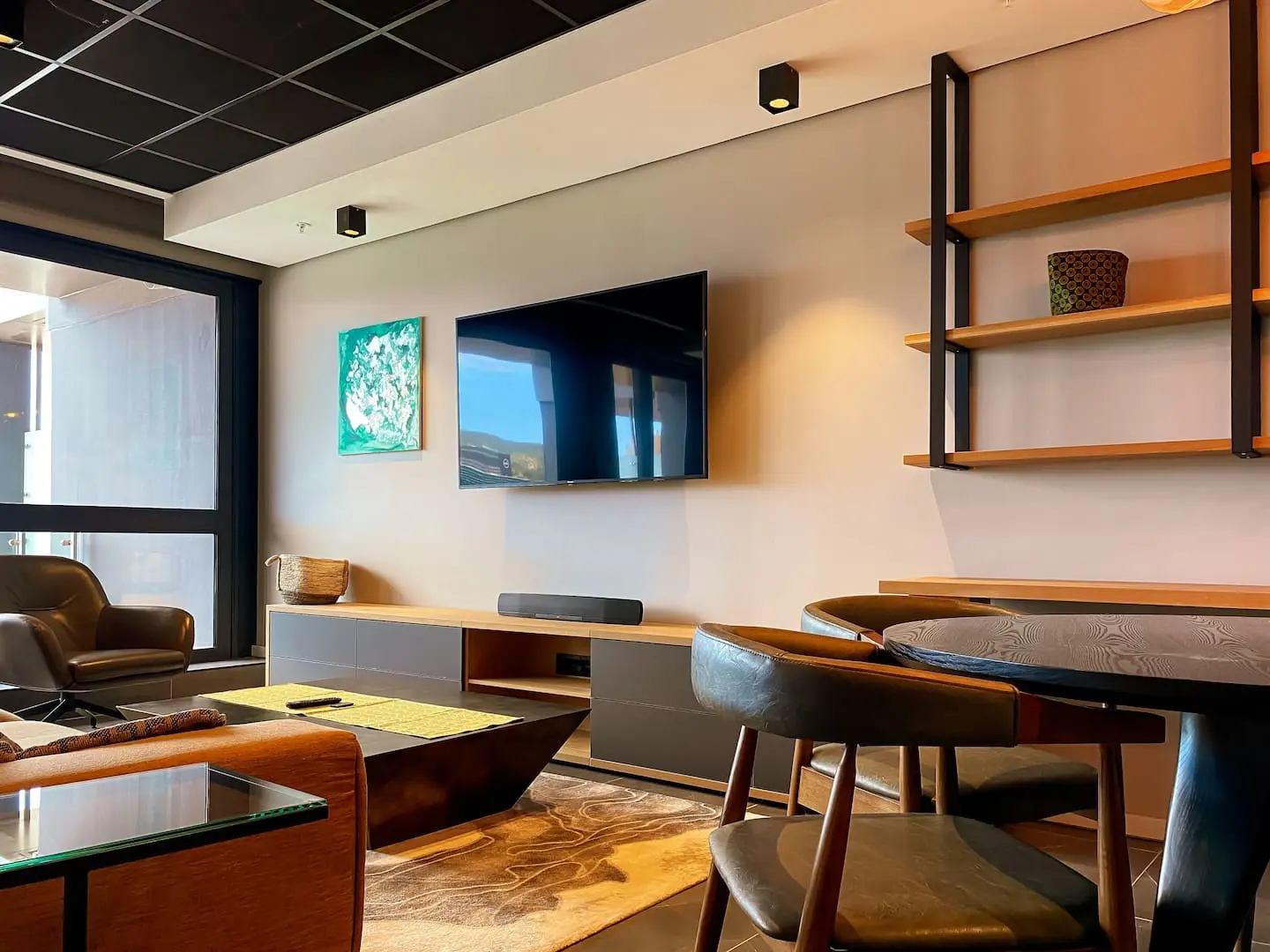  contemporary living area at The Halyard Apartments featuring a large TV, stylish furniture, and modern decor