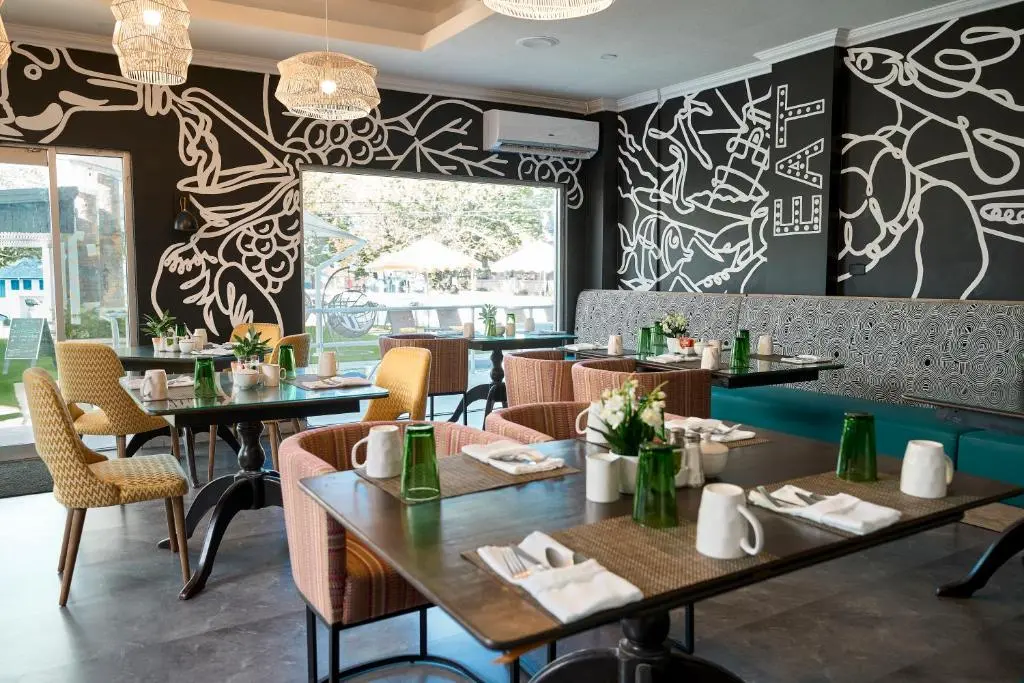 Modern dining area at The Rockley featuring artistic wall designs, stylish seating, and neatly arranged tables set for guests.