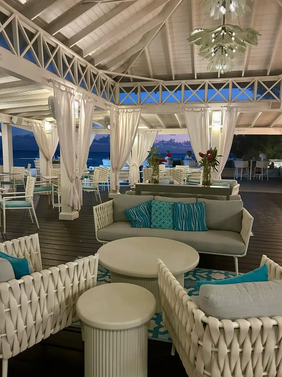 Inviting lounge area at Aqua Terra Restaurant featuring stylish white wicker furniture, vibrant cushions