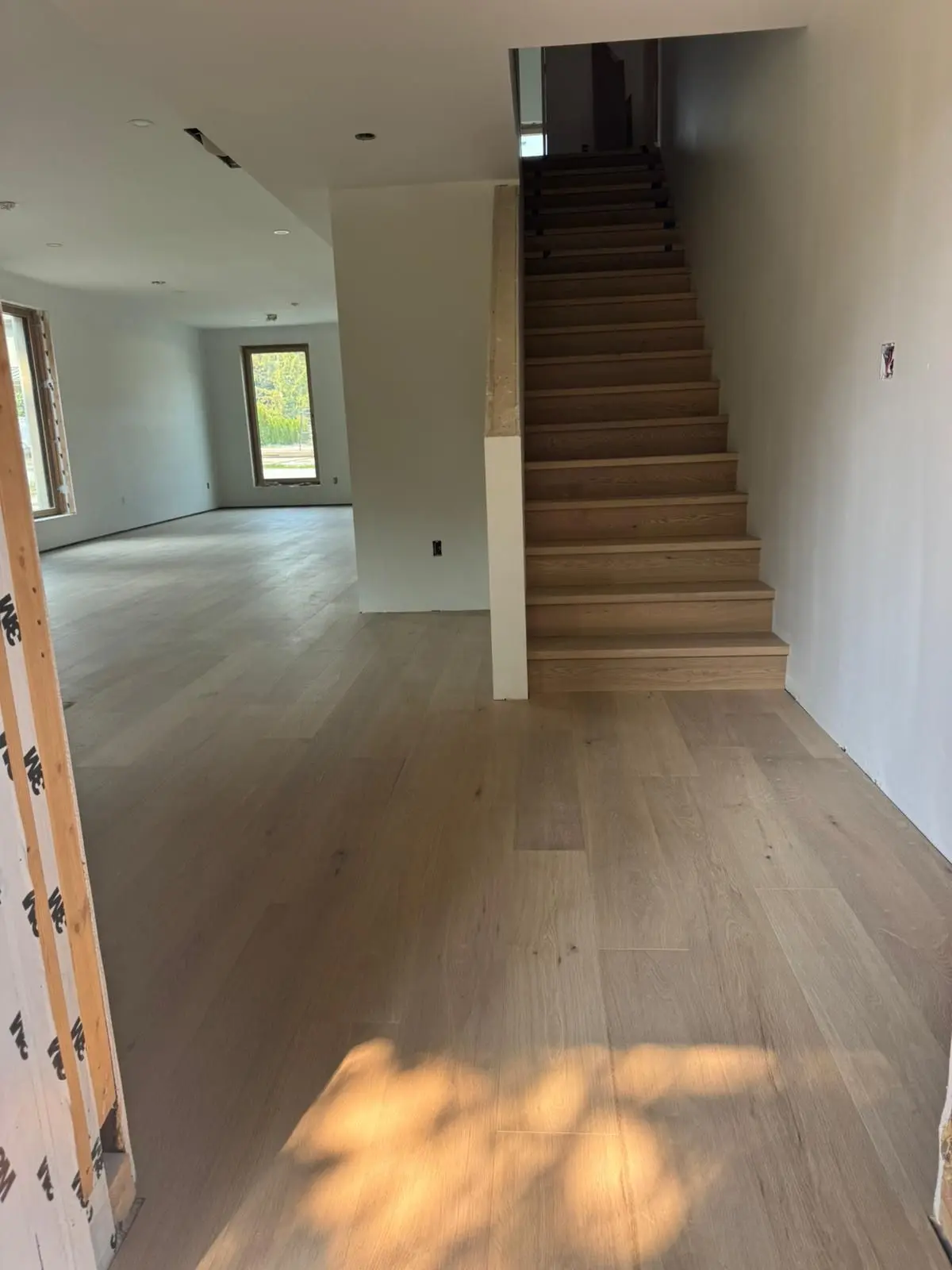 Open-concept living area with timber flooring extending to wooden stairs