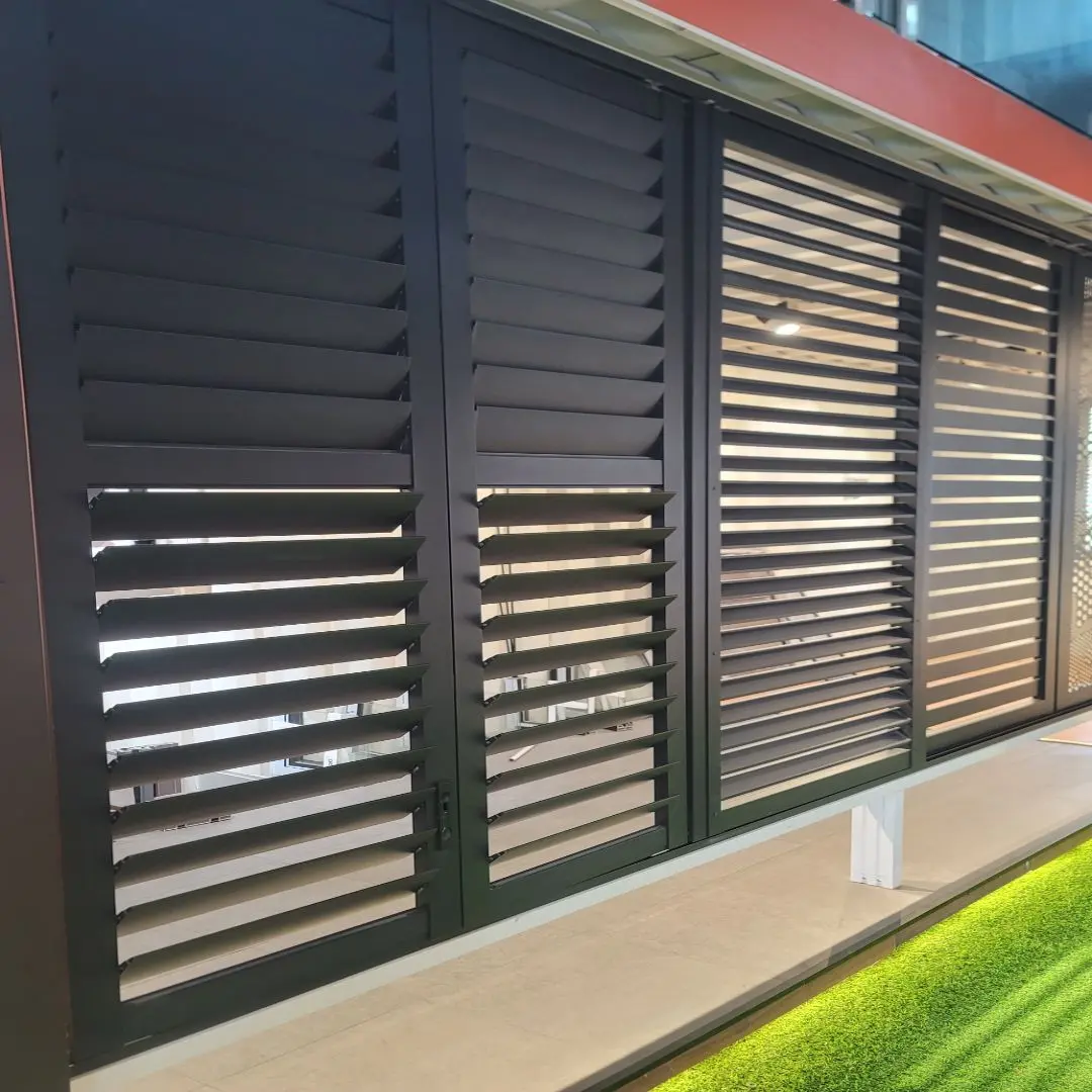 Sourcing Louvers in China Close-up of horizontal metal louvers on a modern building facade, showing dark slats and frame.