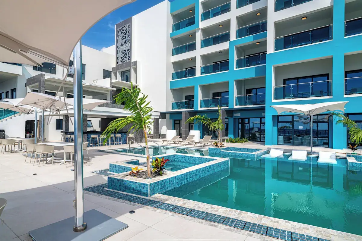 Poolside Dining and Seating - GZS Procurement View of the pool deck and seating areas nestled between the hotel buildings, showing dining tables and chairs, part of the GZS-procured outdoor FF&E.