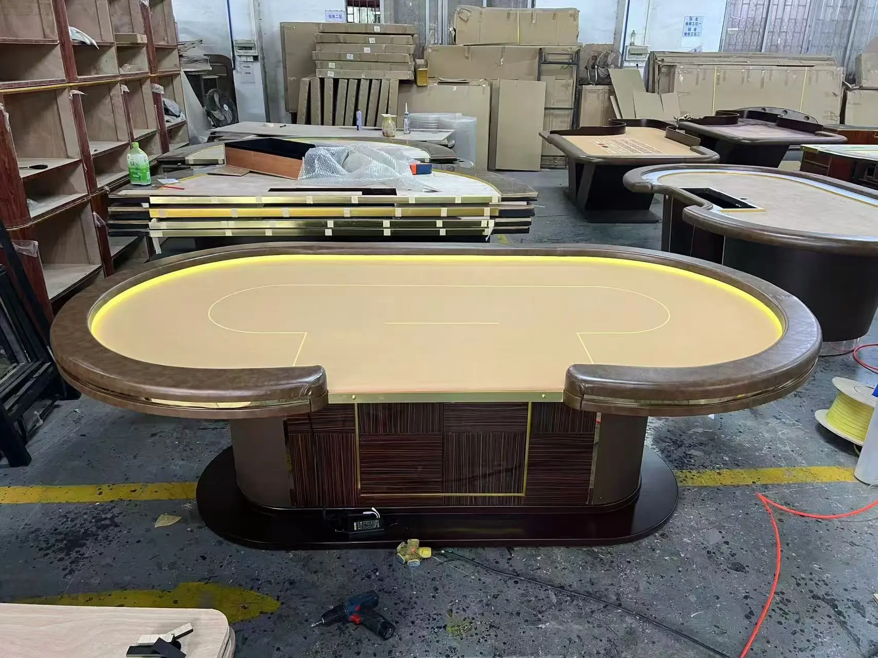 Finished Casino Table Detail - GZS Pre-shipment Inspection Side view of a finished oval casino table with dark wood finish and custom upholstered rail, inspected prior to shipment for the Ocean Oasis Hotel project.