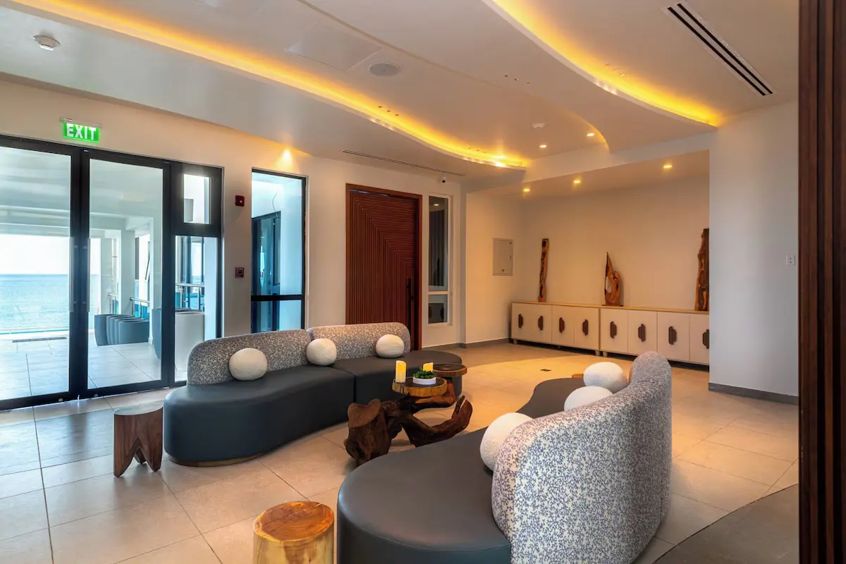 Hotel Lounge Interior Design and Lighting - GZS FF&E Procurement Hotel lounge interior showing custom curved seating, accent cabinetry, and an exit leading to the ocean view, highlighting the quality of GZS-procured furnishings and lighting.