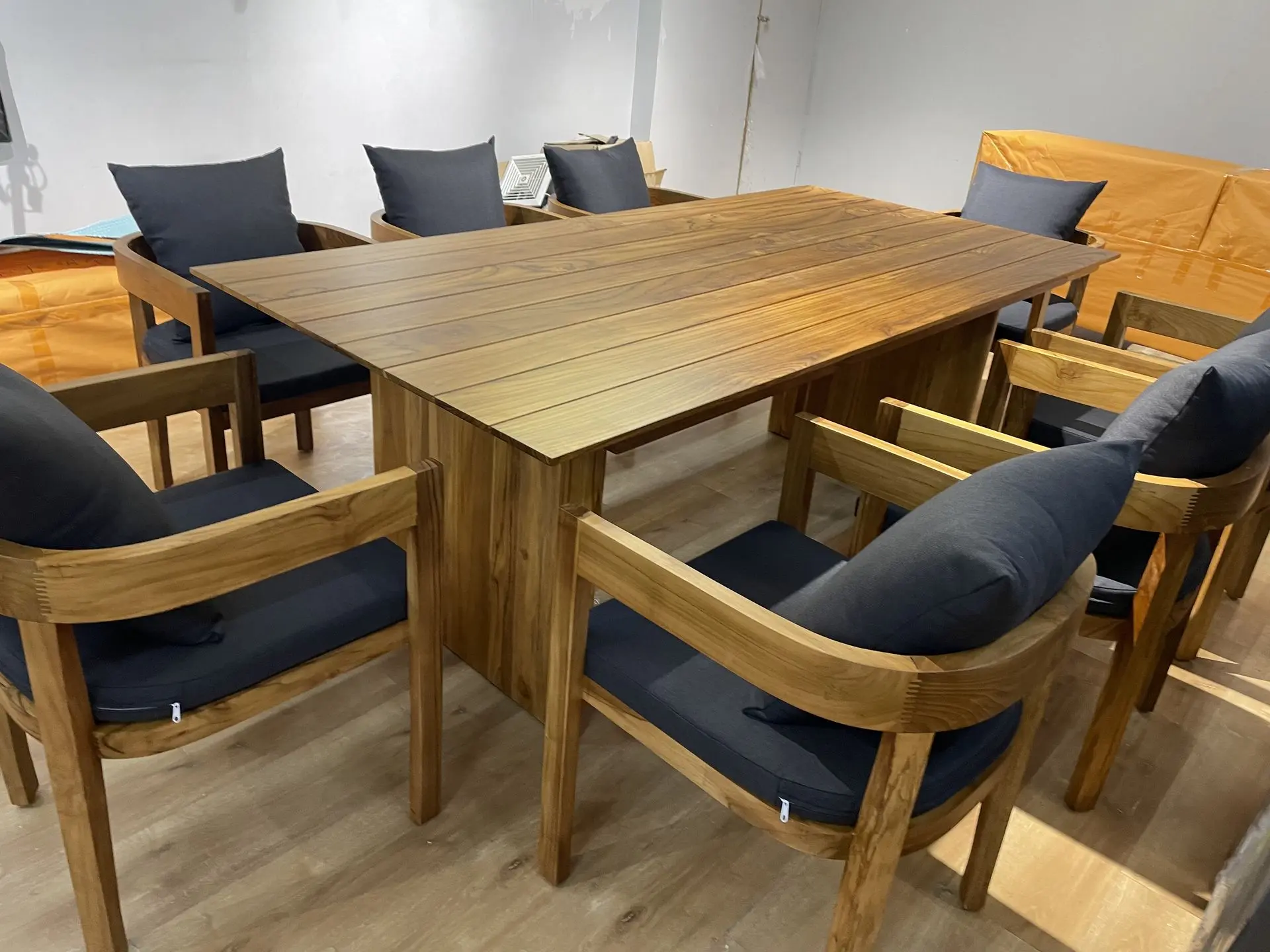 Solid Teak Wood Dining Set Sourcing: Premium Loose Furniture China High-quality solid teak wood dining set with a rectangular table and six matching armchairs with dark gray cushions, sourced as premium loose furniture china for restaurants or residential projects.