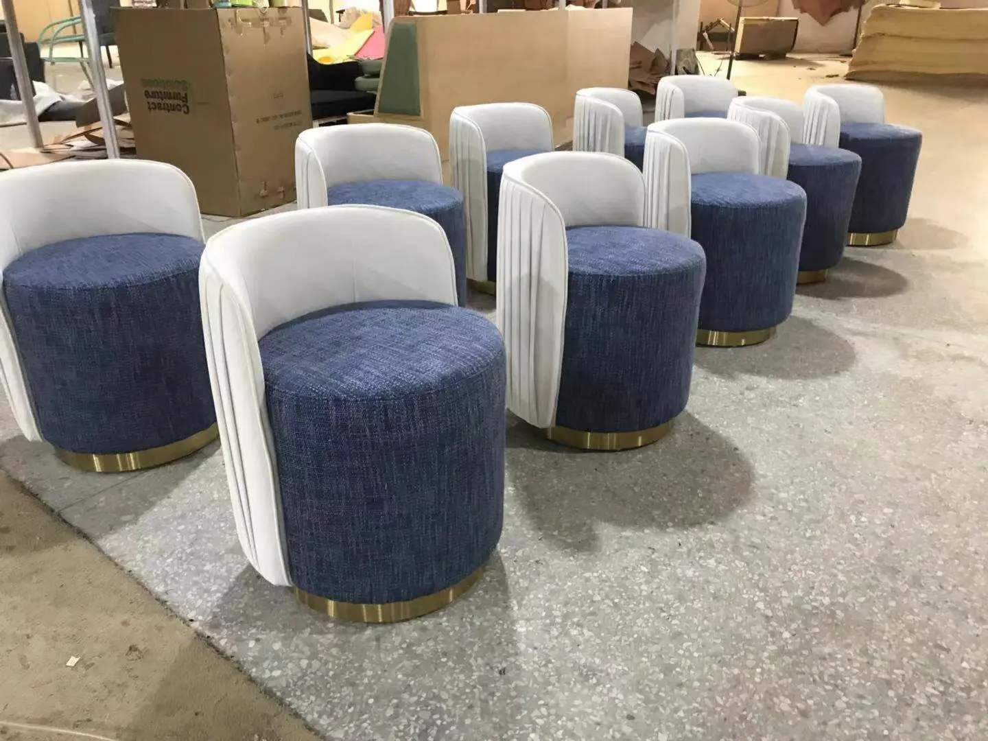 Custom Club Chairs in Bulk: Loose Furniture China Manufacturing Batch of custom contract seating featuring round blue upholstered bases, white pleated barrel-style backrests, and gold metal bases, demonstrating high-volume loose furniture china production.