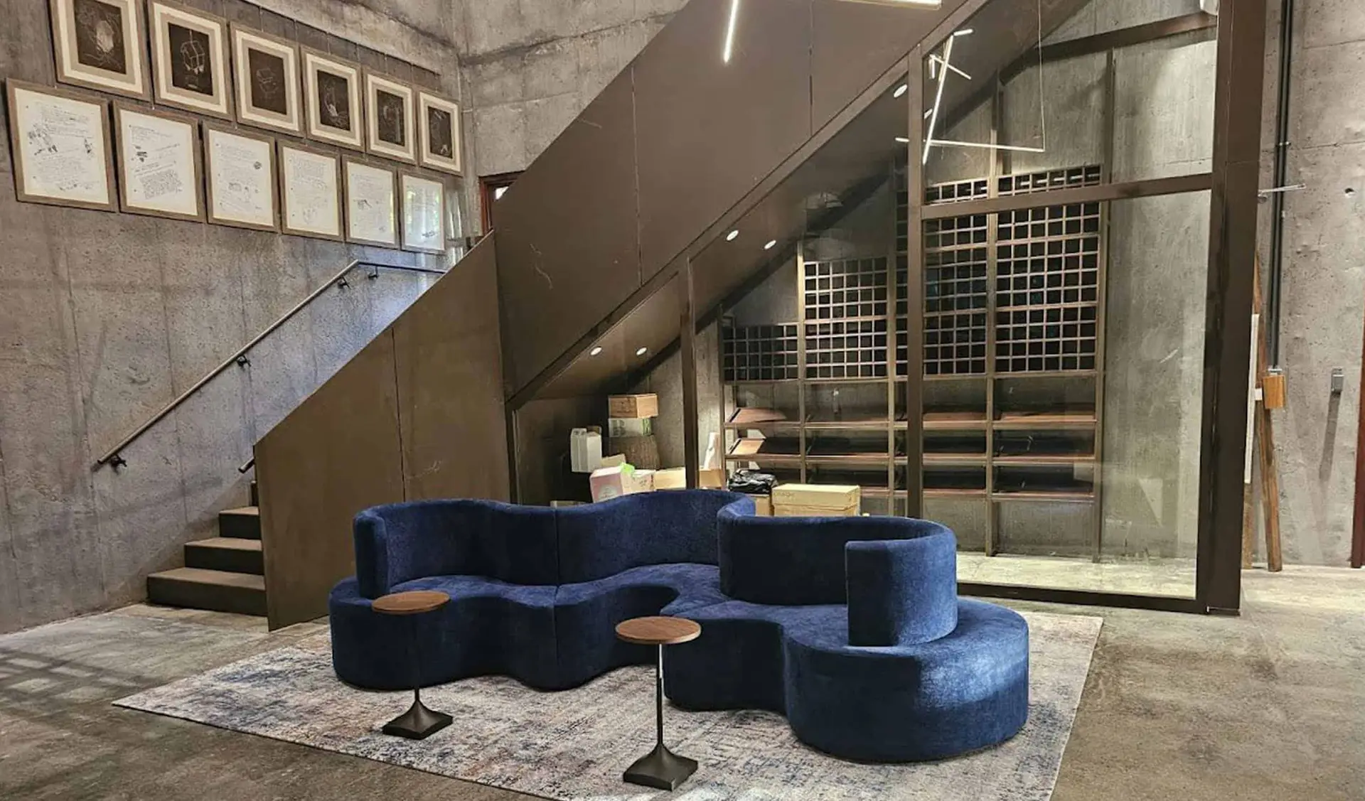 Secret Bay Interior with Custom Sofa and Staircase Design Interior view of Secret Bay featuring a modern blue modular sofa, framed artwork, and custom staircase joinery.