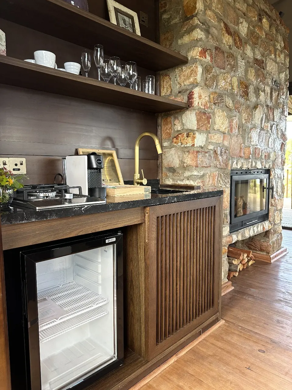 GZS sourced Yamu kitchenette with wood cabinetry, mini-fridge, and stone wall finish.