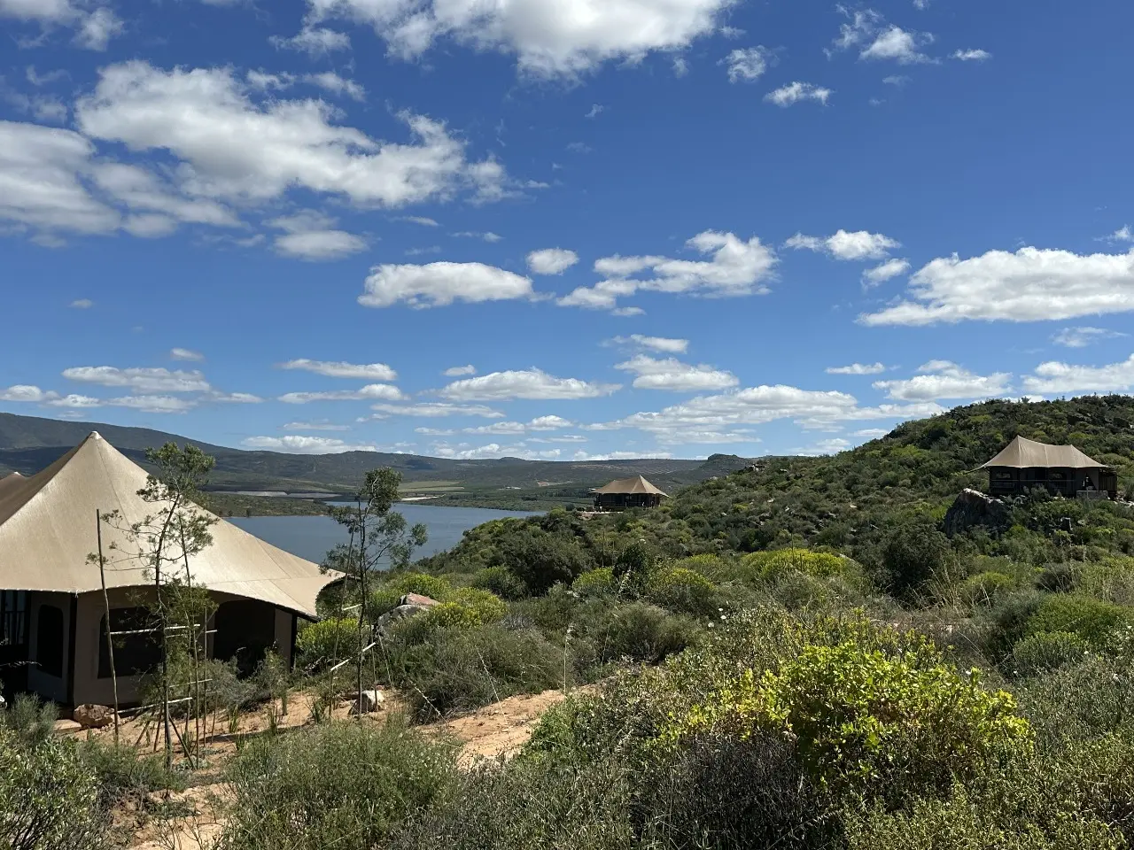 GZS sourced Yamu canvas tent set in a lush green valley with expansive lake views.