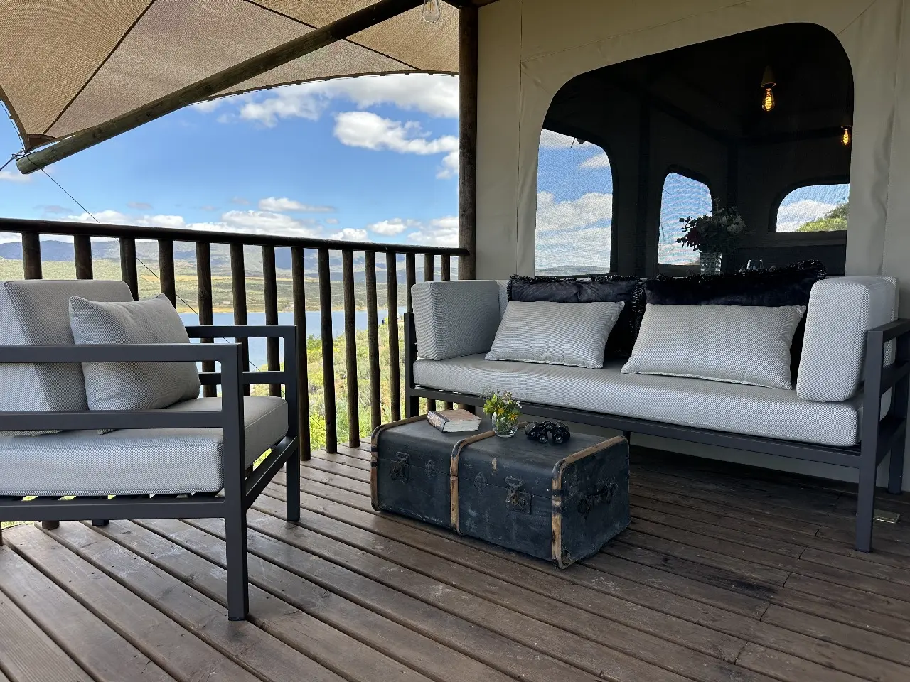 Outdoor sofa with accent pillows and metal-framed armchair on Yamu’s elevated deck.