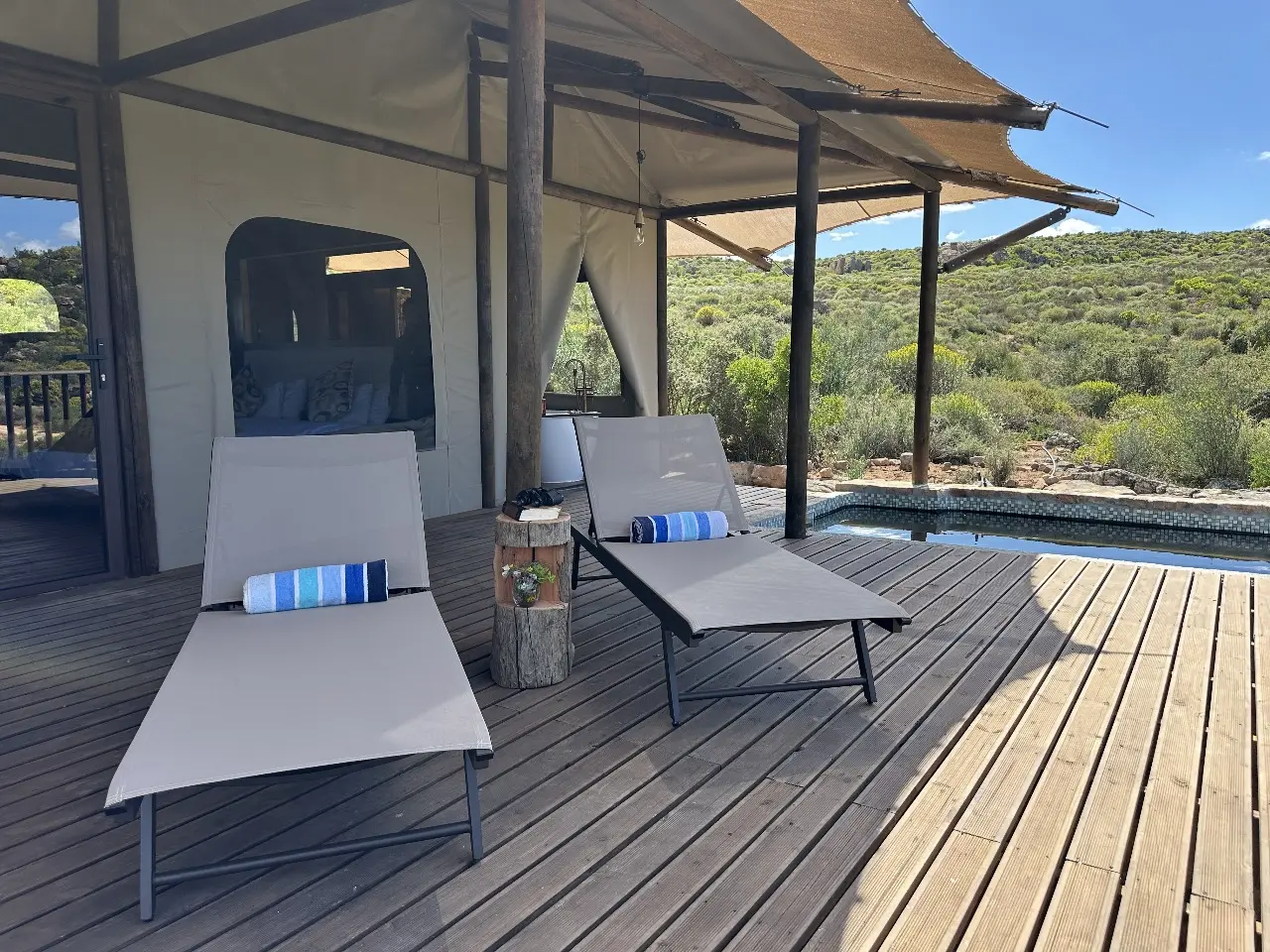 Outdoor loungers placed beside Yamu tent suite with expansive landscape views.