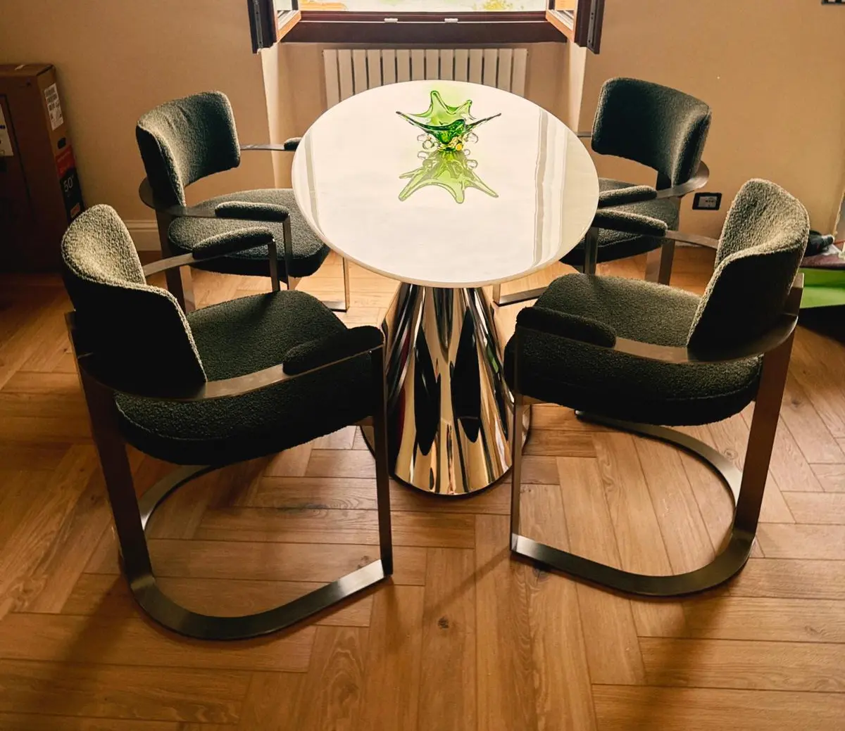 Elegant dining set at Lake Como Boutique Hotel featuring a polished metal base table and upholstered modern chairs, part of GZS sourced loose furniture.