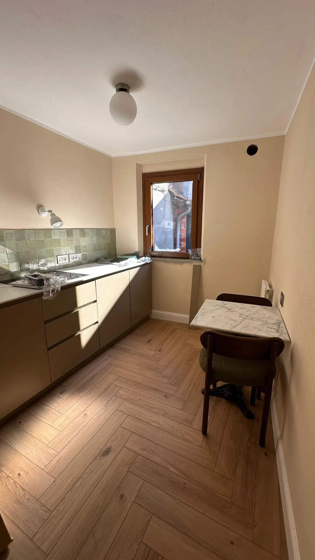 Compact hotel kitchen with minimalist cabinets and small dining nook, furnished by Guangzhou Sourcing for the Lake Como Boutique Hotel.