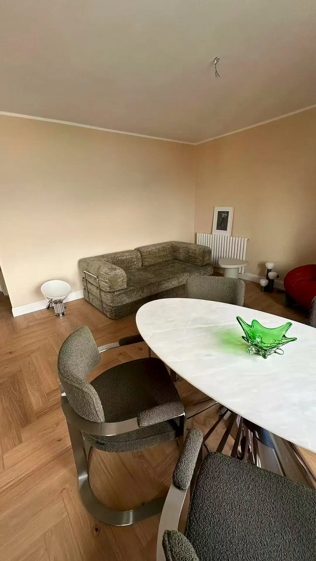 Living room with green sofa and marble dining table, part of Guangzhou Sourcing’s curated interiors for the Lake Como Boutique Hotel.