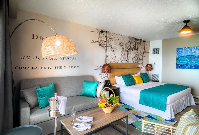 Step into a luxurious hotel room boasting a lavish bed, a stylish couch, and a captivating wall mural, evoking a sense of grandeur and artistic charm. Elegant hotel room adorned with a plush bed, a cozy couch, and a captivating wall mural, exuding opulence and tranquility.