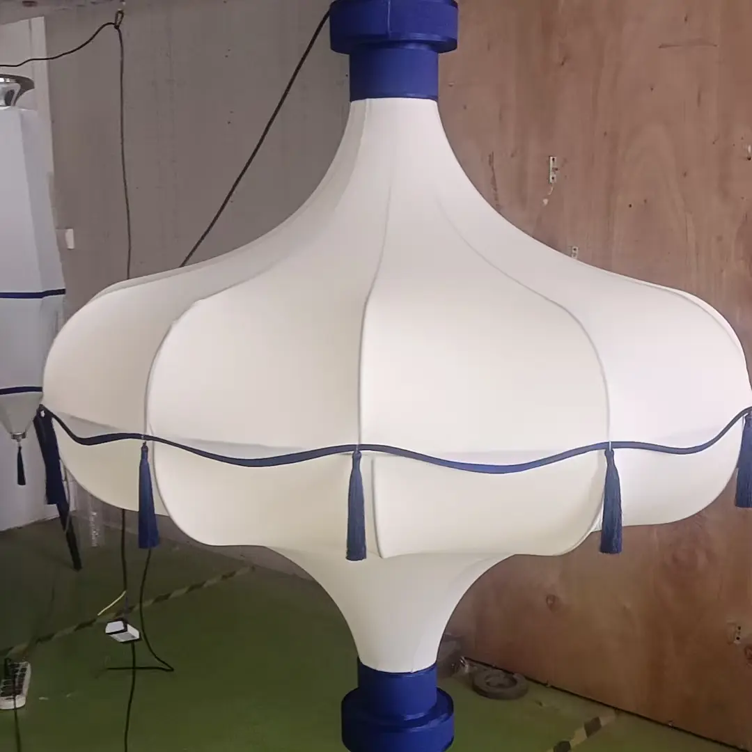 Custom-made decorative light fitting with fabric cover and blue tassel accents for interior design projects