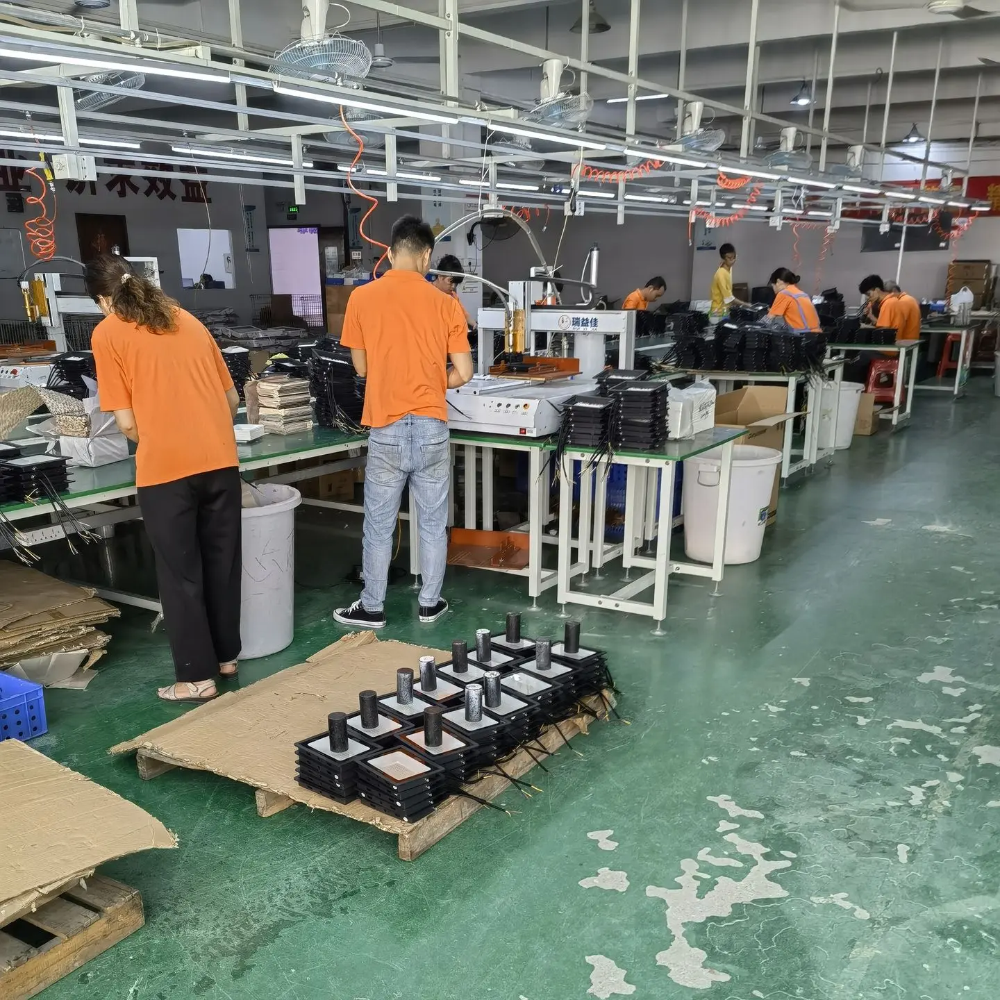 Lighting factory in China with workers assembling light fixtures during production process