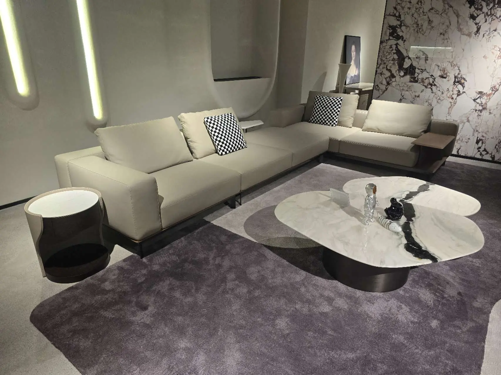 Modern luxury living room furniture set displayed in a showroom with sectional sofa, marble coffee table, and accent lighting