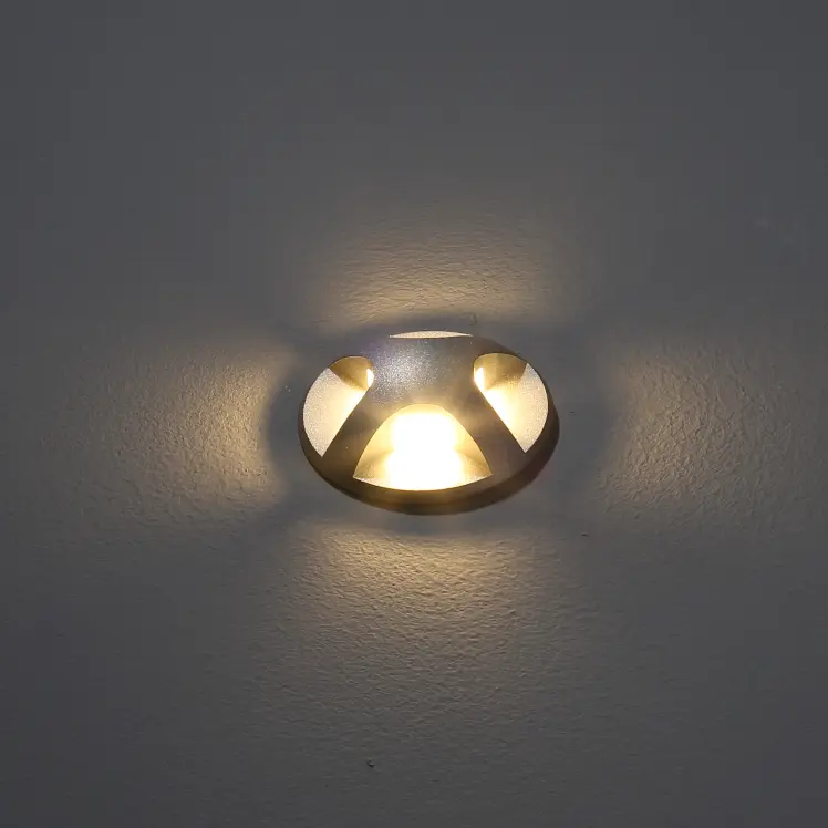 Lámpara de pared exterior moderna que proyecta una iluminación cálida sobre una pared