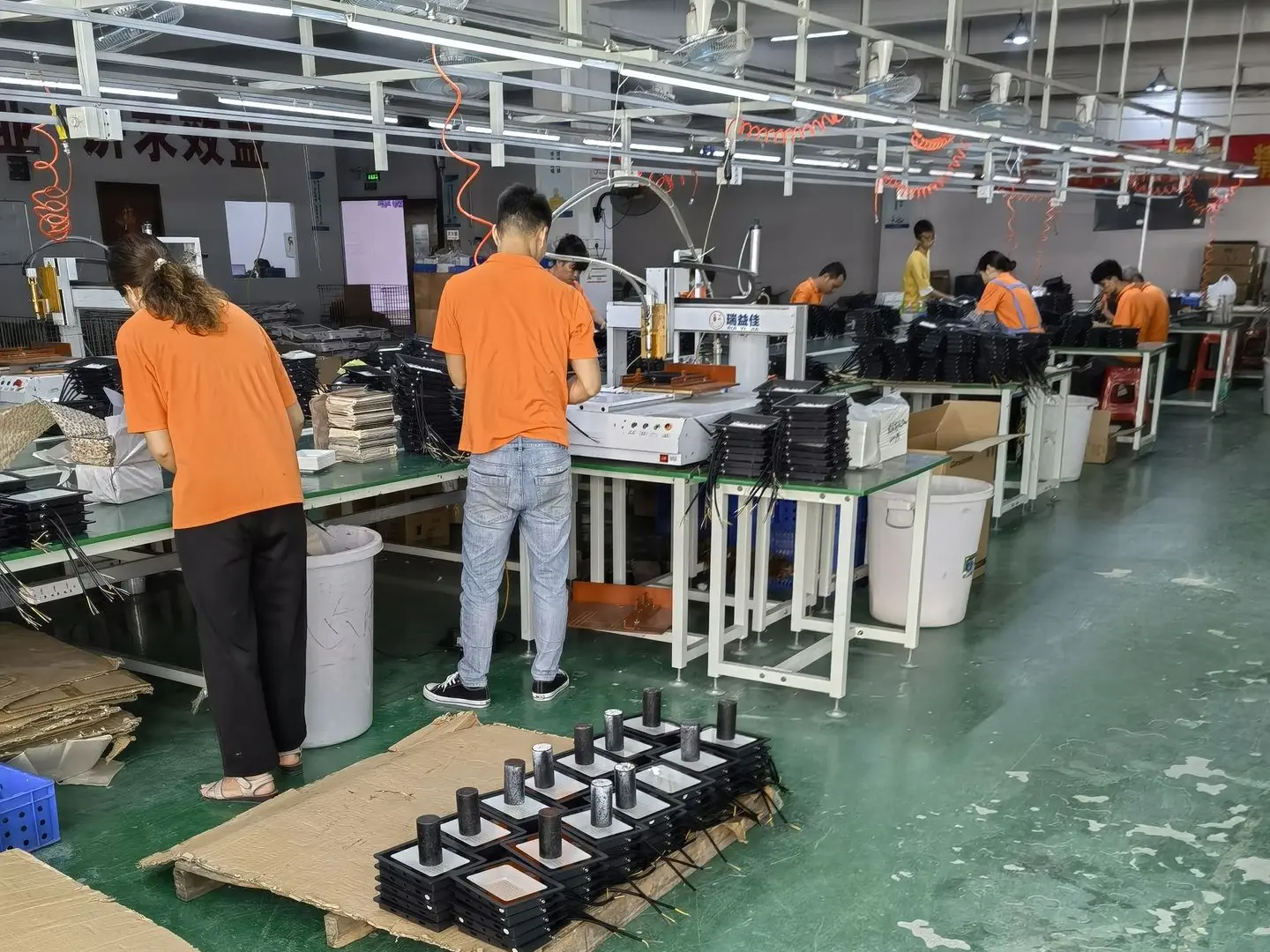 Lighting factory production line in China with workers assembling bespoke lighting components.