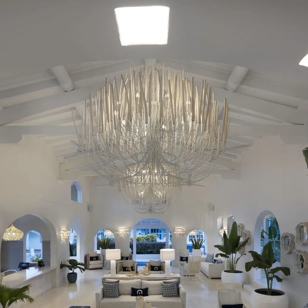 Luxury interior with grand custom chandelier installation in a modern white lounge space.