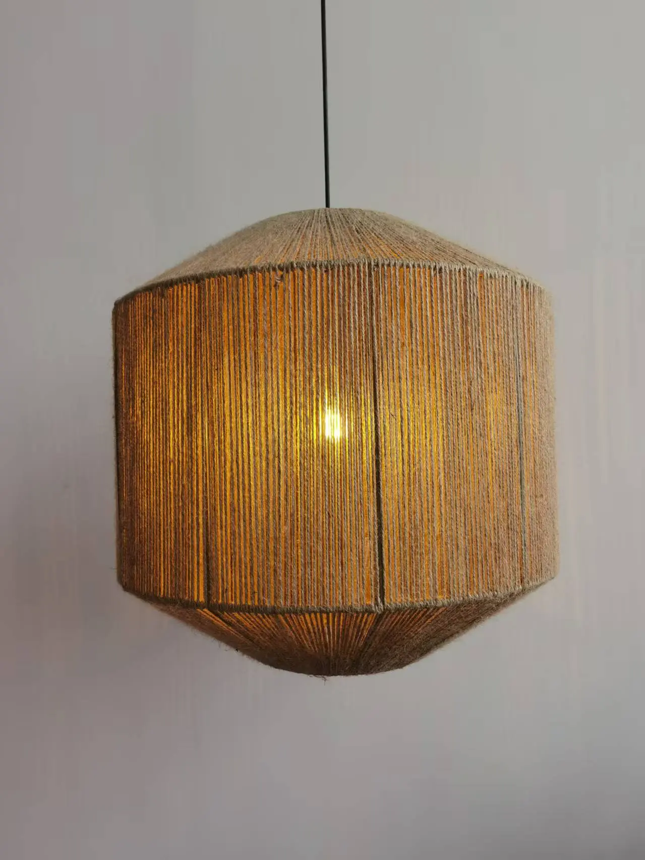Octagon-shaped woven pendant lamp glowing warm light, ideal for sourcing rattan light in China for interior design projects.