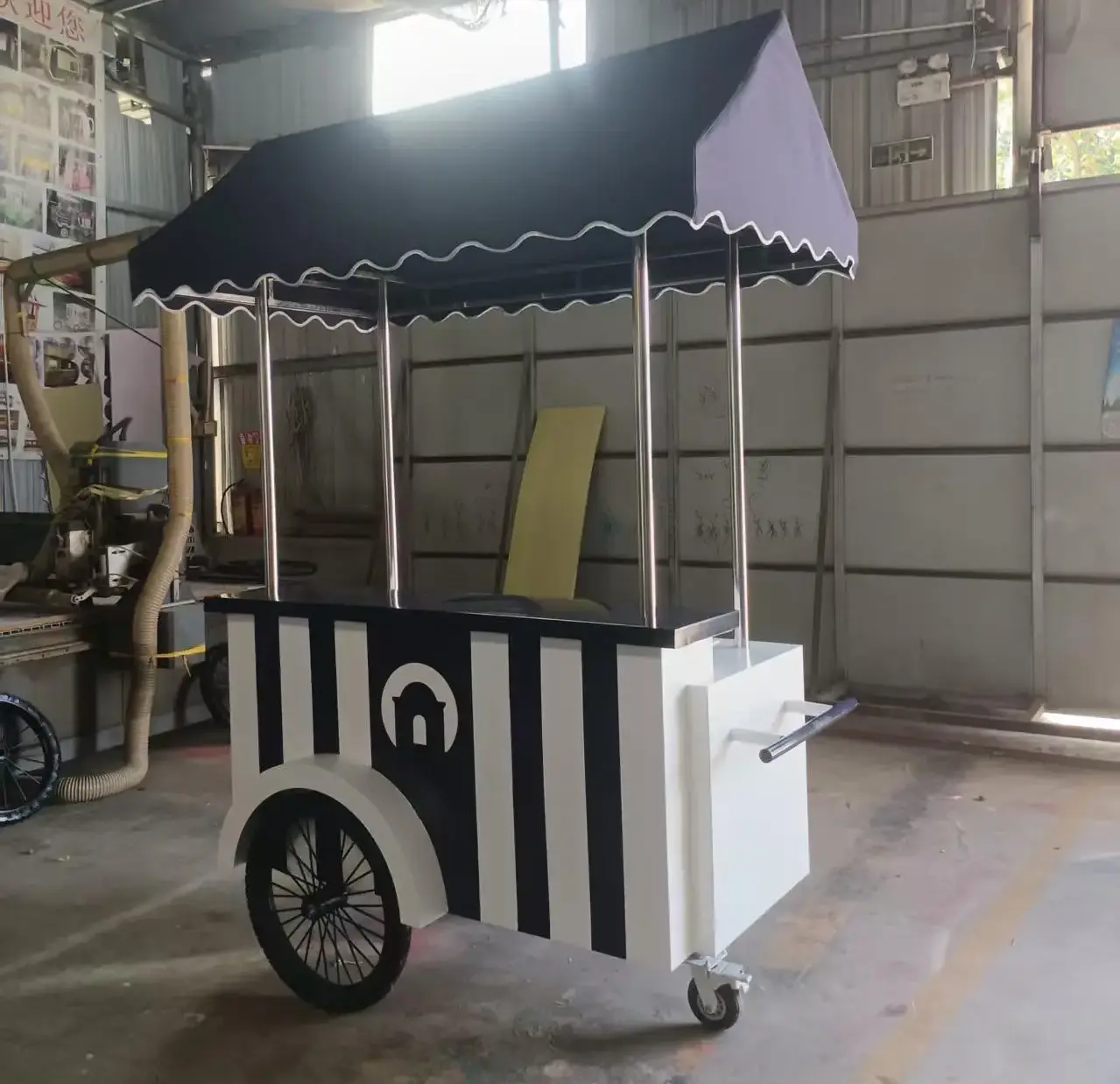 Custom food cart with striped panels and canopy manufactured for Windjammer Landing, showcasing GZS sourced mobile service solution.