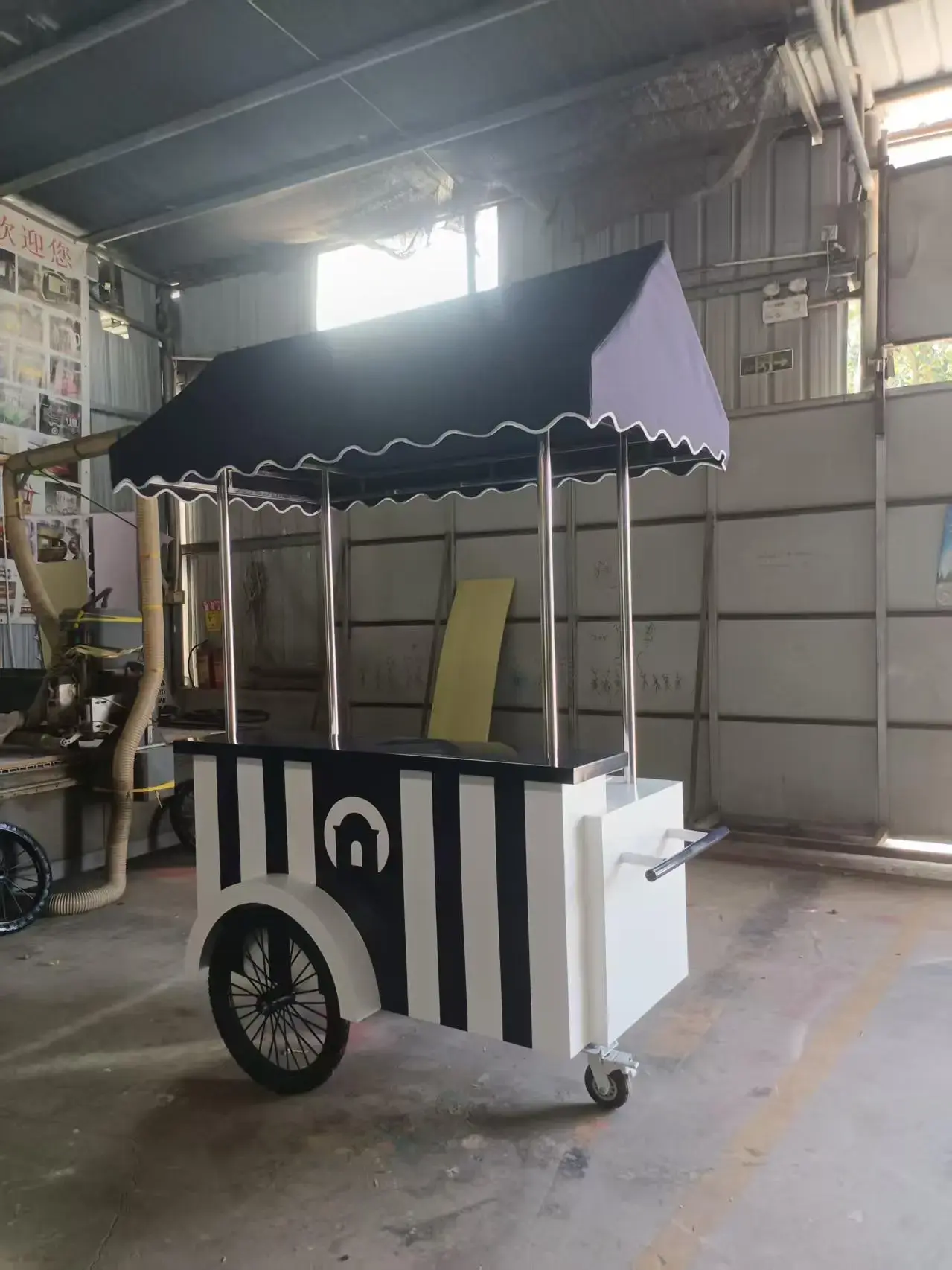 Custom food cart with striped panels and canopy manufactured for Windjammer Landing, showcasing GZS sourced mobile service solution.