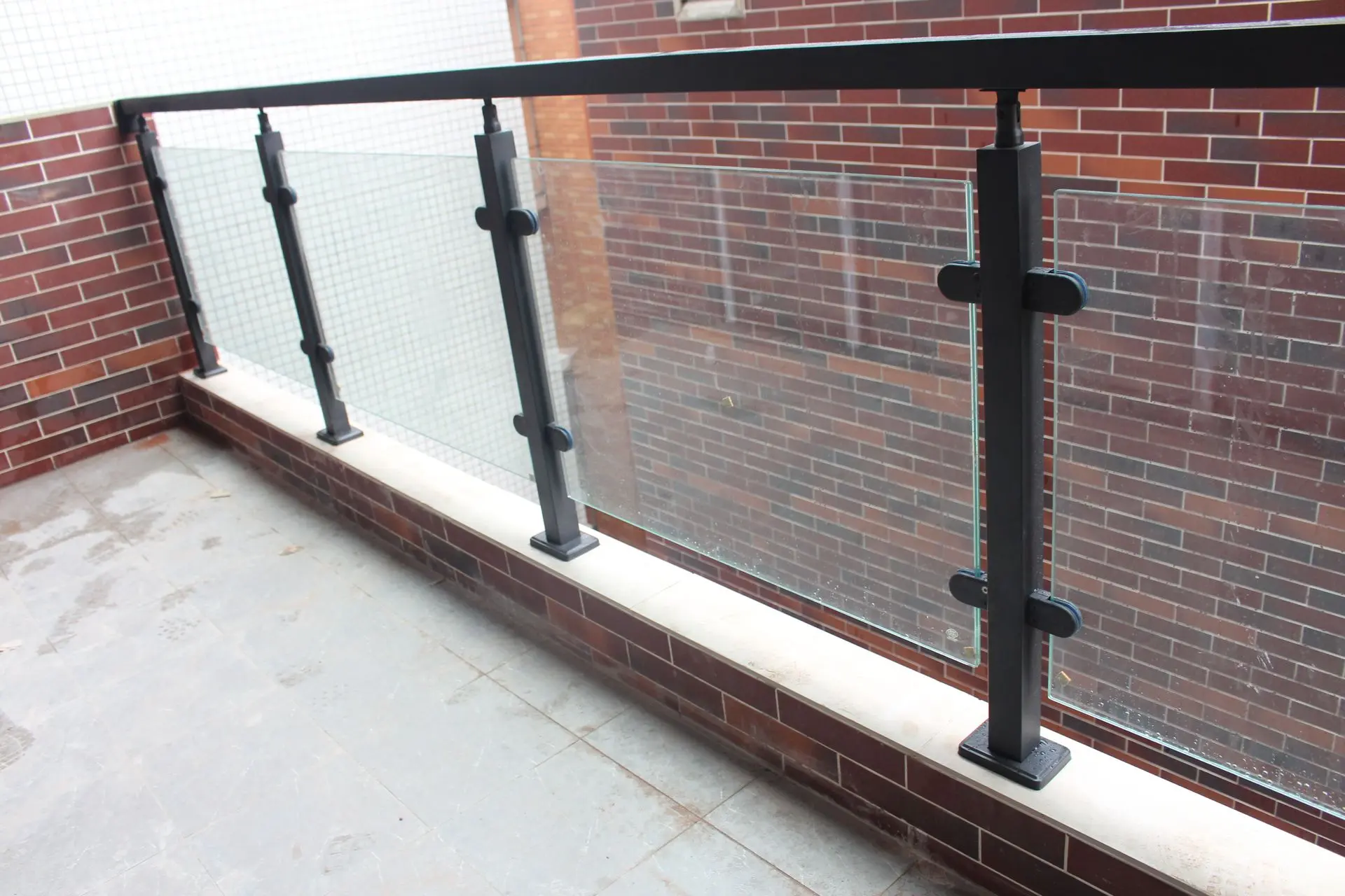 Glass balcony railing system with black metal posts showcasing modern railings in China for residential and commercial applications