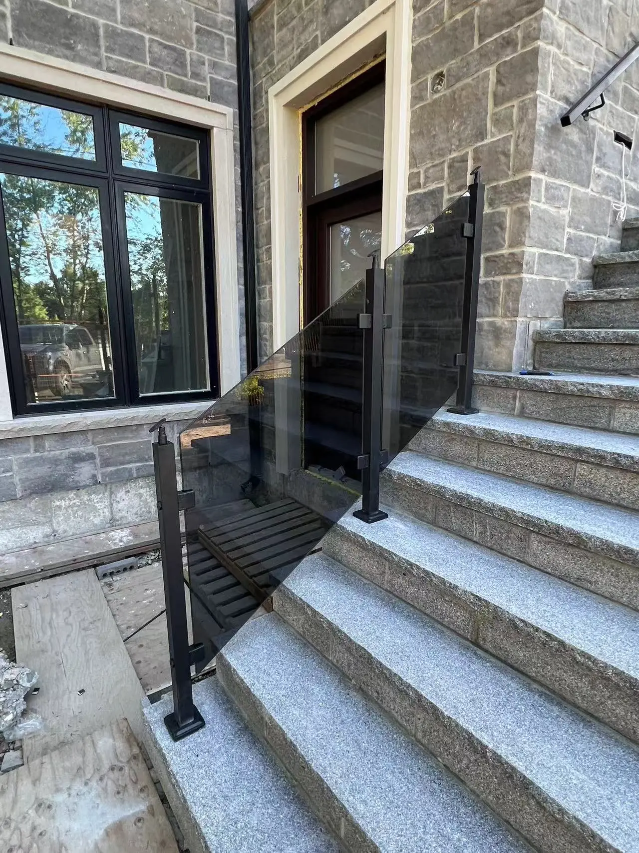 Exterior staircase with glass panel system and black metal posts highlighting durable railings in China for residential buildings