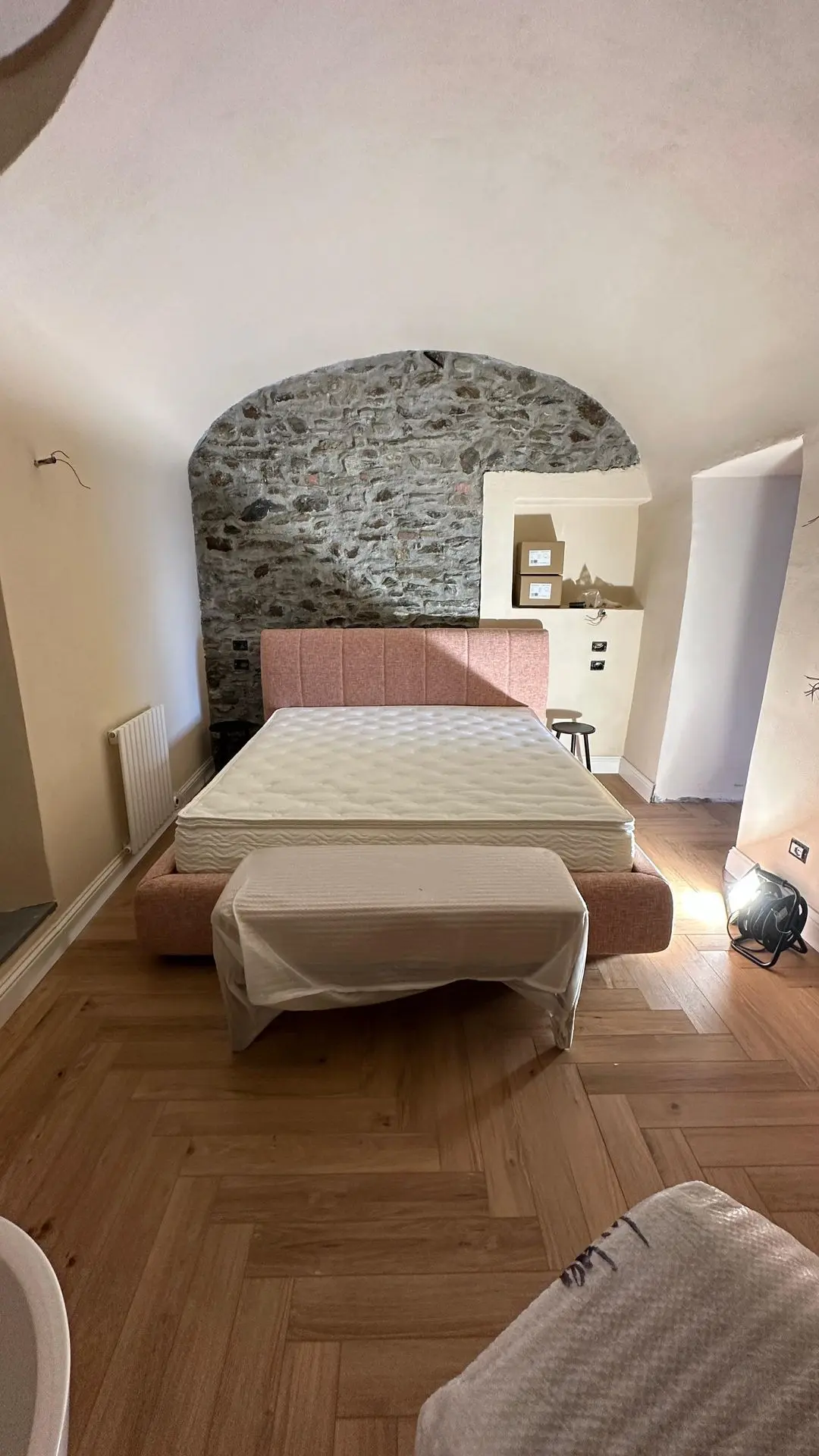 Boutique hotel room with stone arch and custom bed