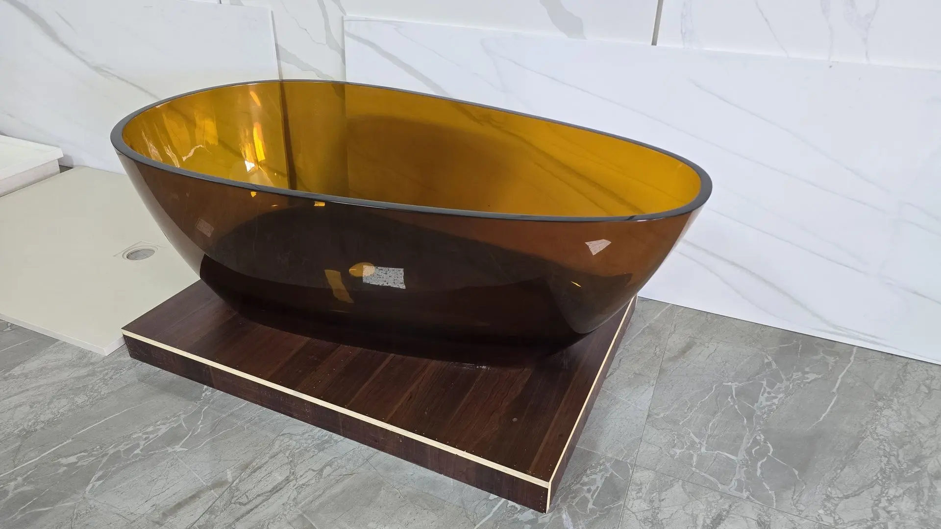 Amber transparent freestanding bathtub showcasing modern minimalist design and custom luxury bathroom trends